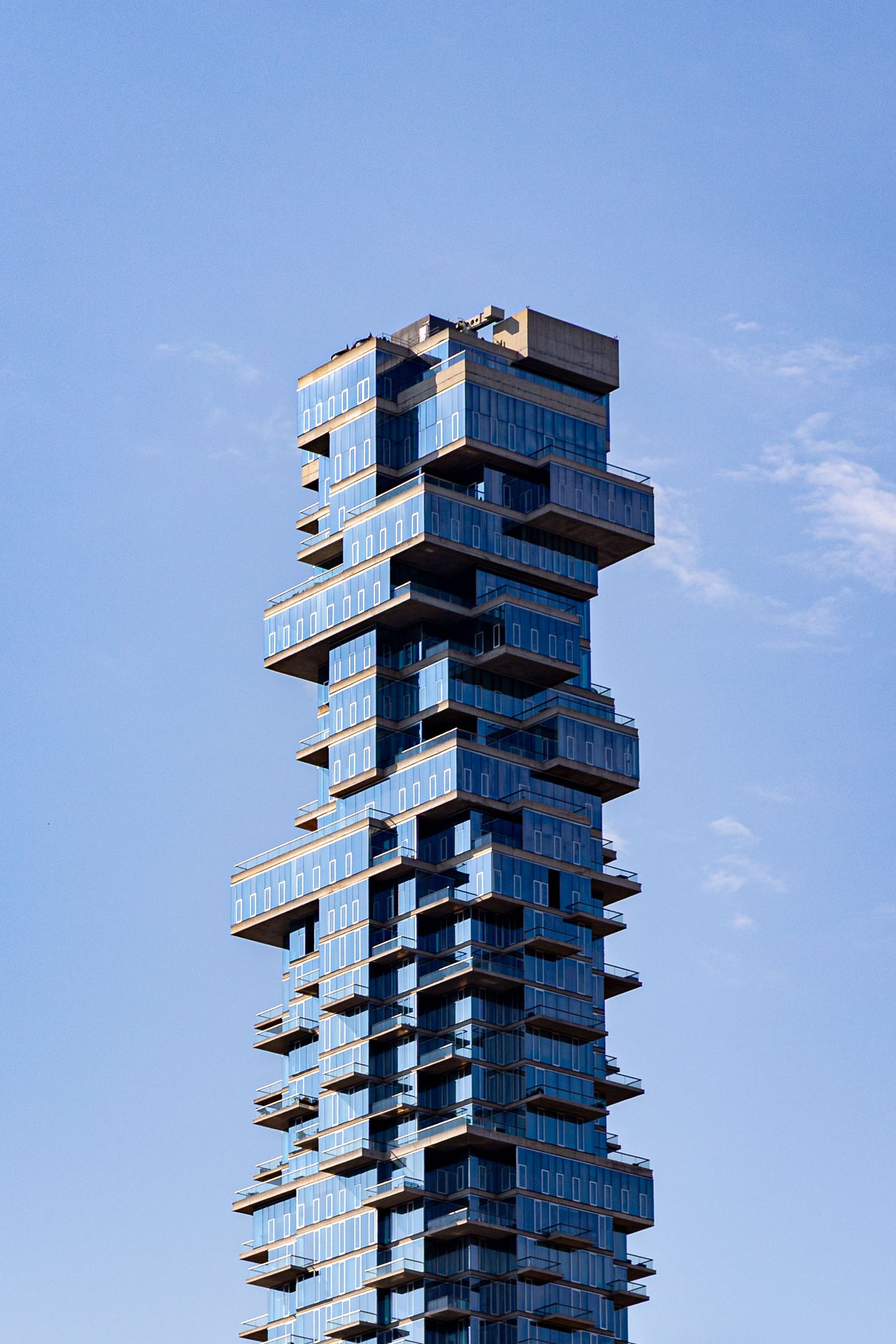 New York City residential tower with glass balconies and blue sky Manhattan