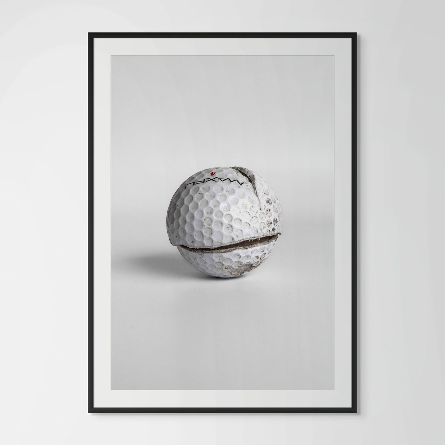 Maxfli Revolution cracked golf ball framed photography print in black wood frame