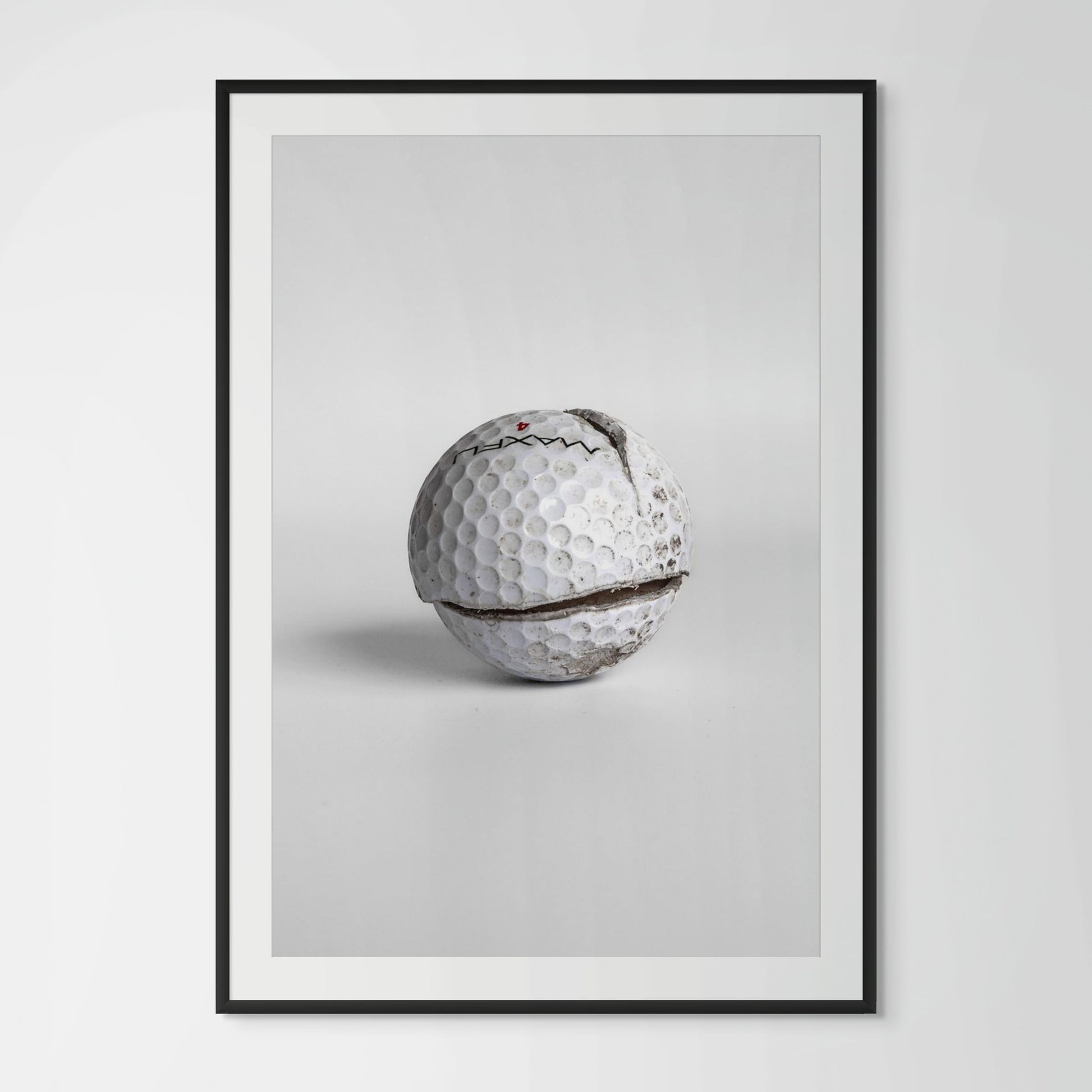 Maxfli Revolution cracked golf ball framed photography print in black wood frame