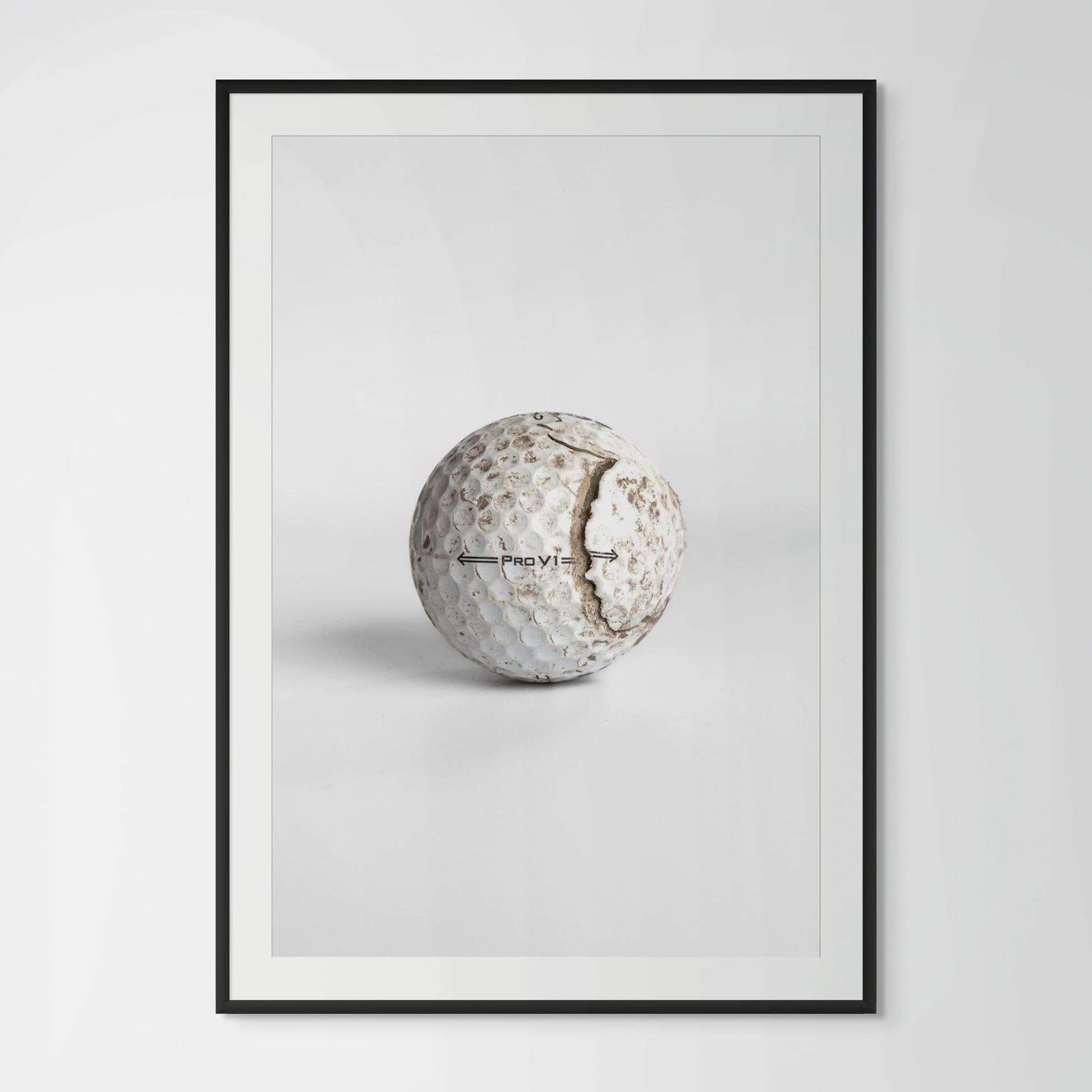 Titleist Pro V1 aged cracked golf ball framed photography print in black wood frame