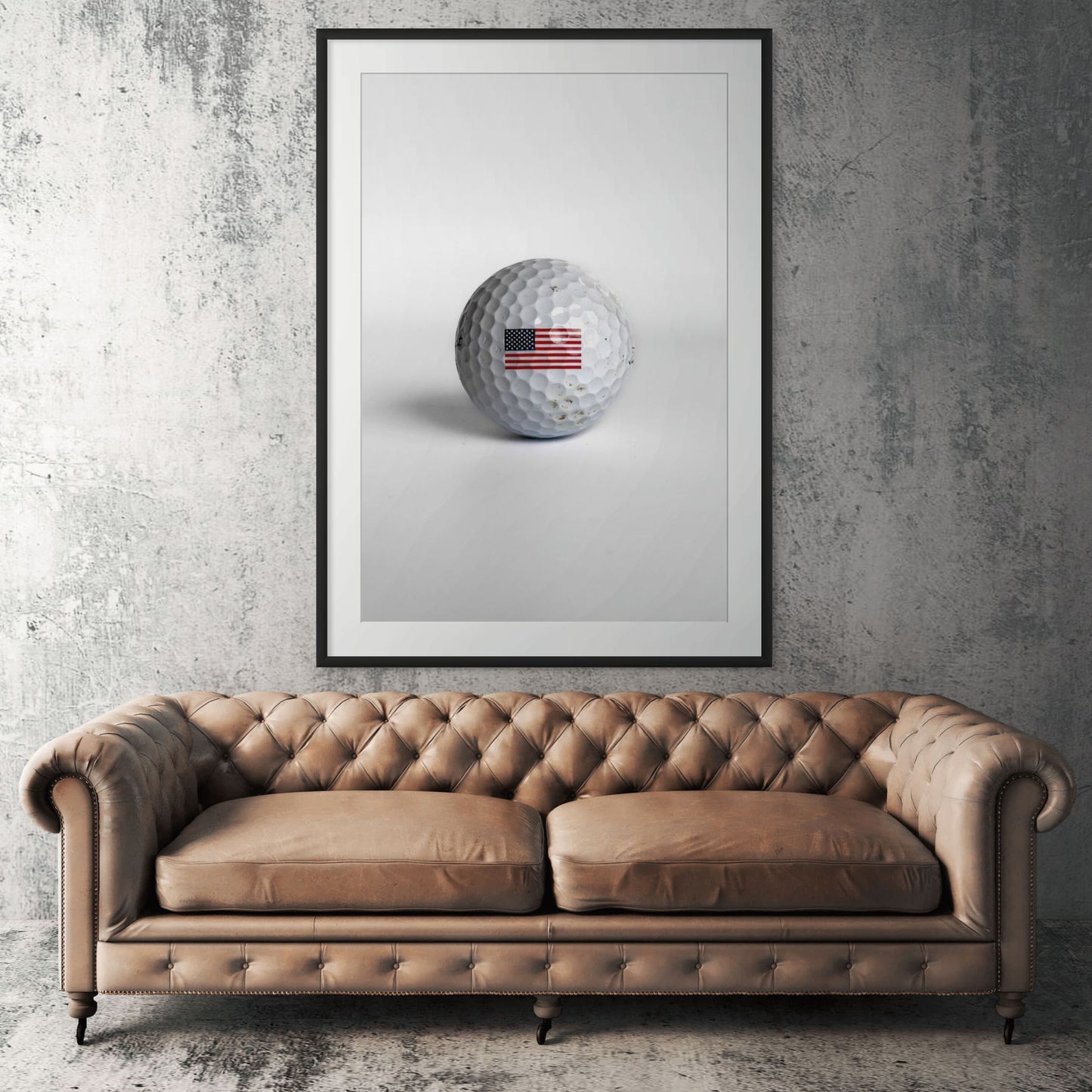 Titleist Pro V1 American flag golf ball framed print displayed above tan leather sofa in living room