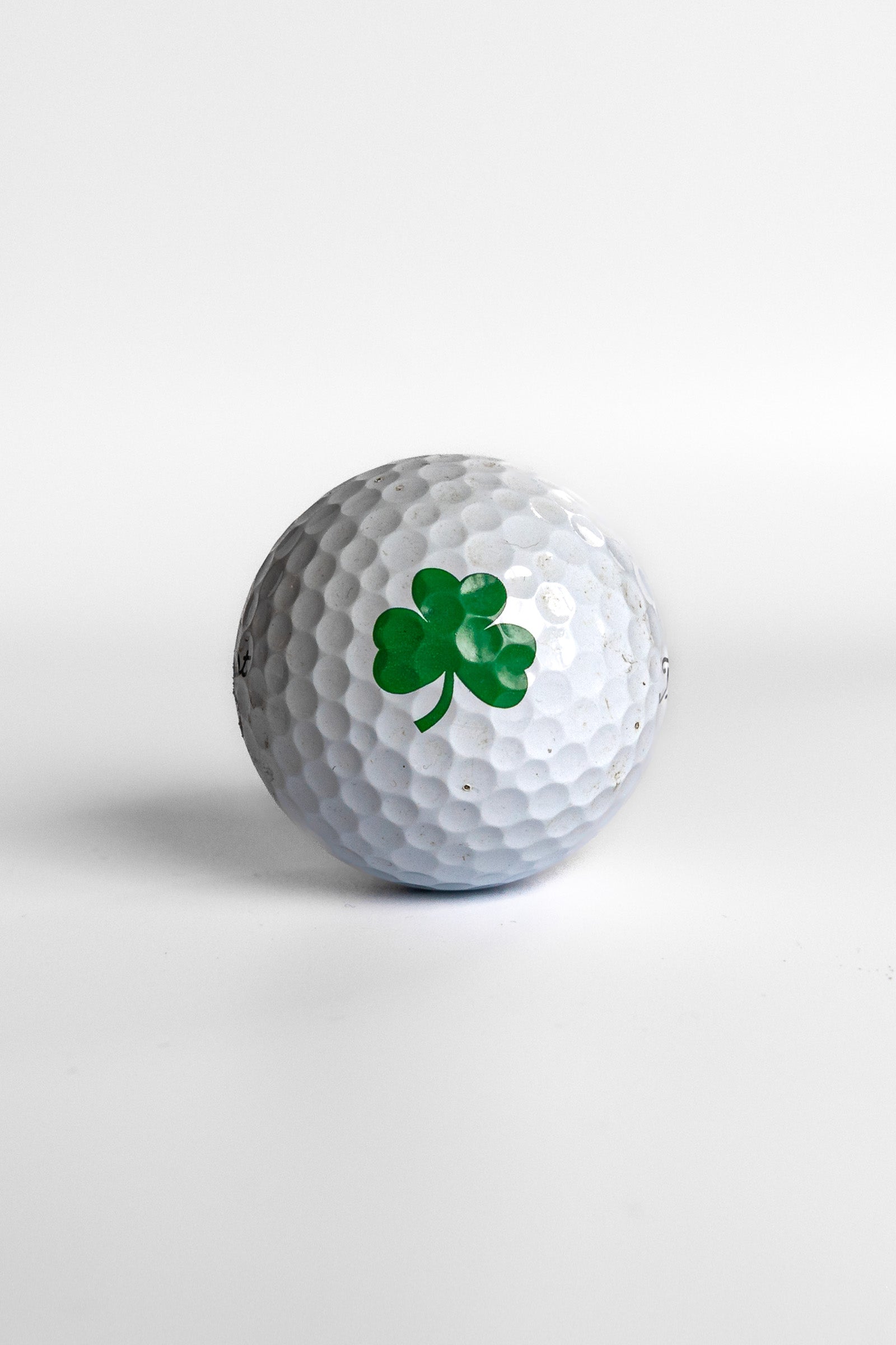 Titleist Pro V1 golf ball with green shamrock clover graphic white background