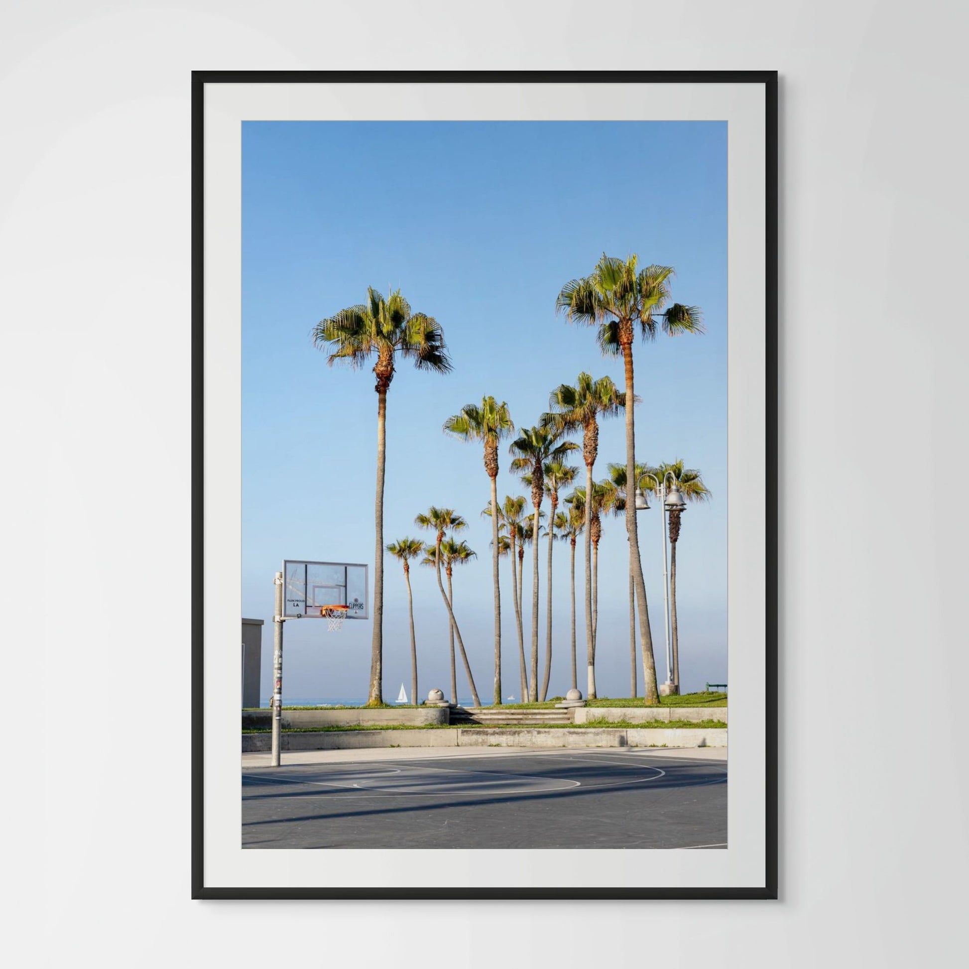 Venice Beach outdoor basketball courts with palm trees and ocean view at golden hour California