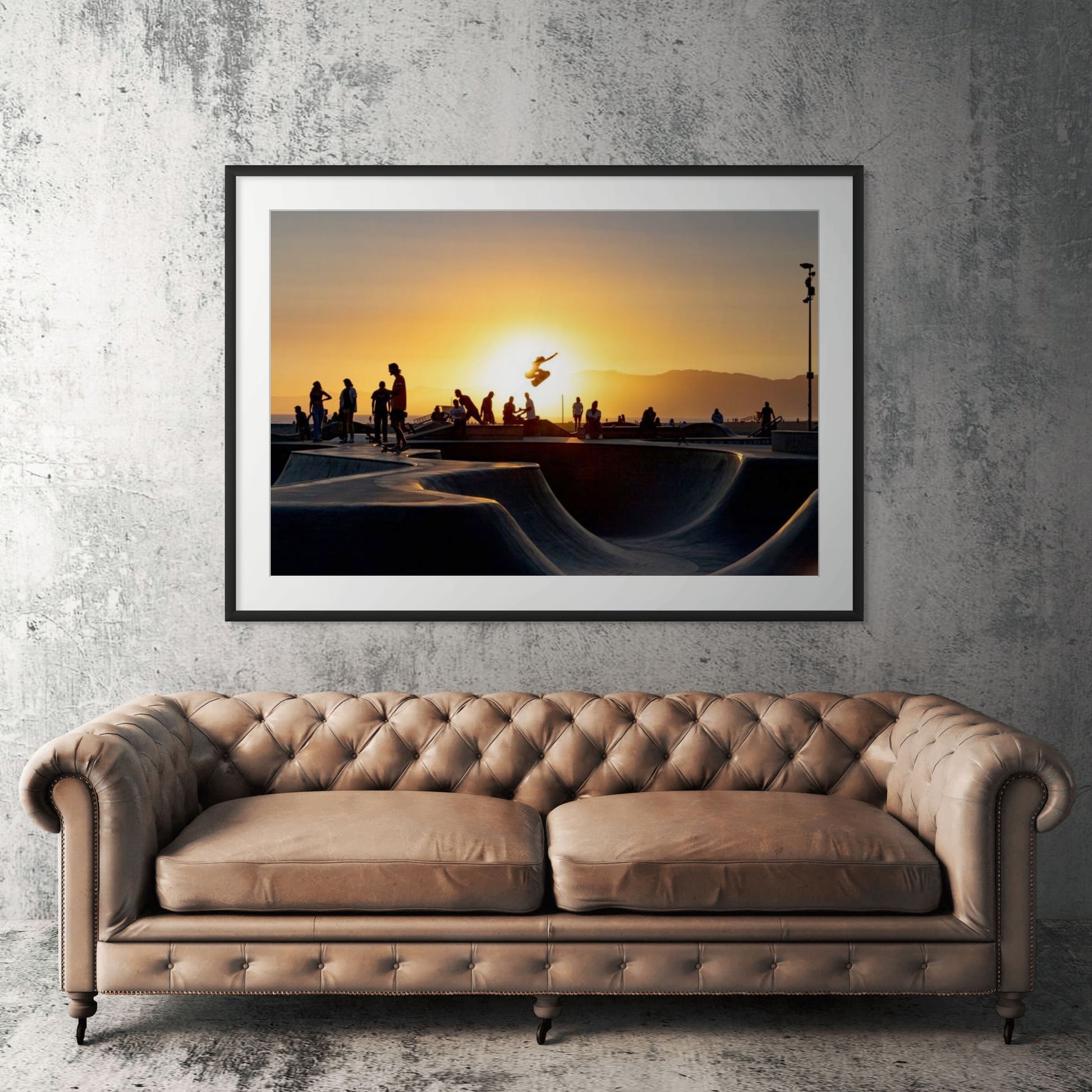 Venice Beach skatepark framed print displayed above tan leather sofa in living room